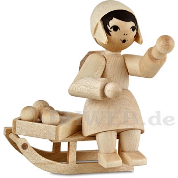 Girl on the sledge with christmas ornaments, natural wood