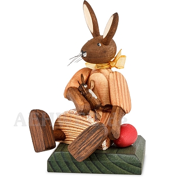 Easter bunny girl sitting with orange dress and doll